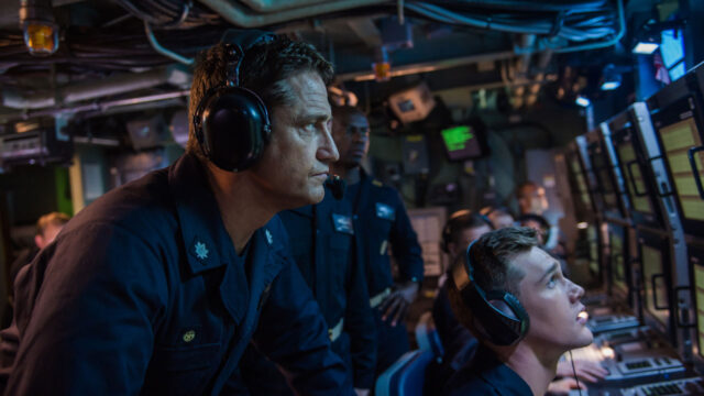 Gerard Butler como Joe Glass observa monitores ao lado de tripulação em submarino no filme Fúria em Alto Mar