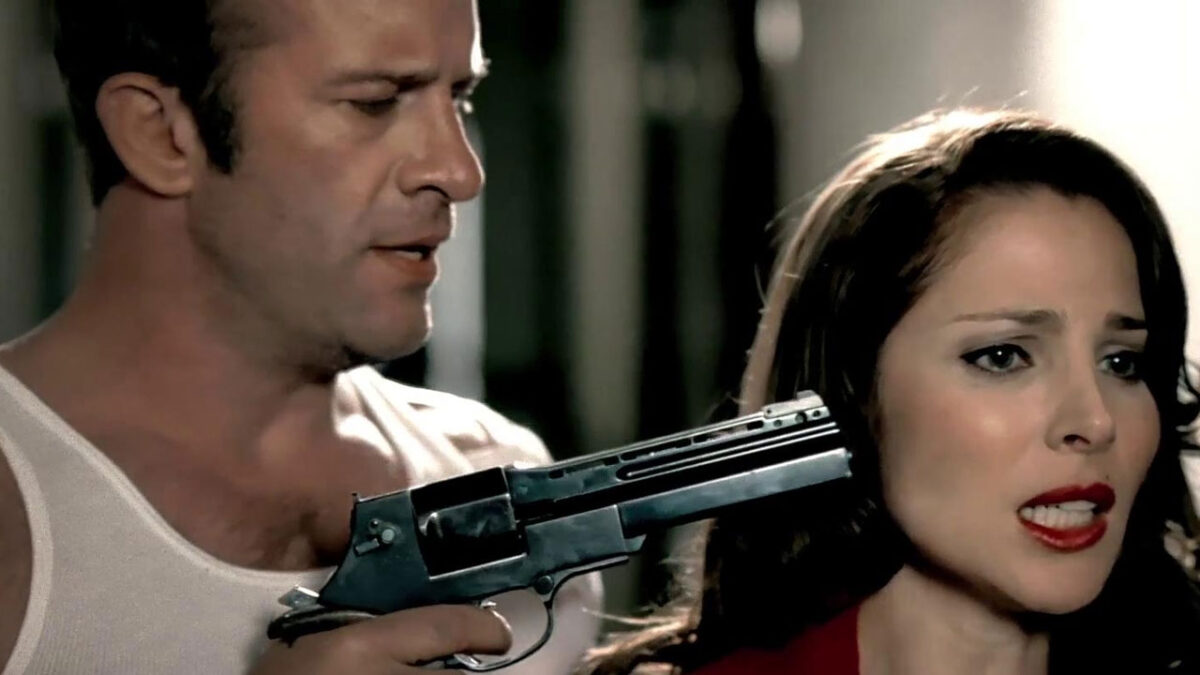 Malone aponta arma para a cabeça de Evelyn em cena tensa do filme Malone: Puxando o Gatilho de 2009