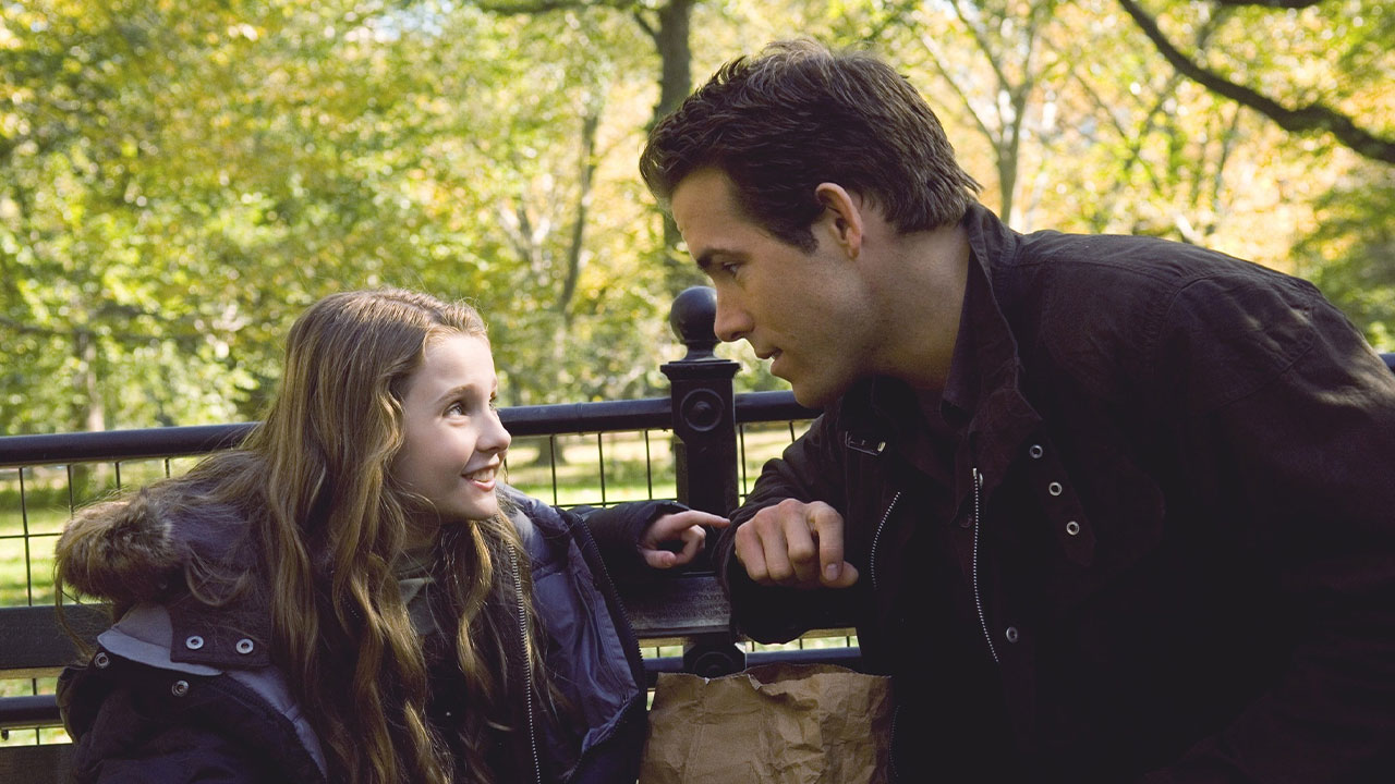 Maya Hayes (Abigail Breslin) e Will Hayes (Ryan Reynolds) conversando em banco de parque em cena do filme Três Vezes Amor de 2008