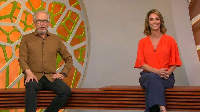 Nélson Araújo com camisa marrom e Helen Martins com blusa laranja apresentam o Globo Rural sentados no estúdio da Globo