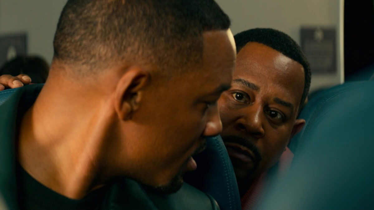 Mike Lowrey (Will Smith) e Marcus Burnett (Martin Lawrence) sentados em avião em cena do filme Bad Boys para Sempre de 2020