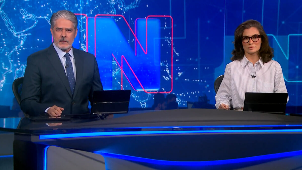William Bonner e Renata Vasconcellos apresentam o Jornal Nacional no estúdio da TV Globo com telão azul ao fundo