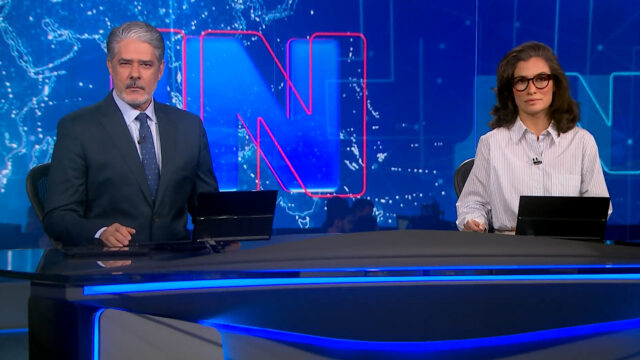 William Bonner e Renata Vasconcellos apresentam o Jornal Nacional no estúdio da TV Globo com telão azul ao fundo