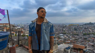 Xamã caracterizado como Bagdá usando camisa jeans e óculos escuros em gravação da novela Três Graças