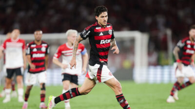 Pedro corre em campo com uniforme do Flamengo durante partida de futebol