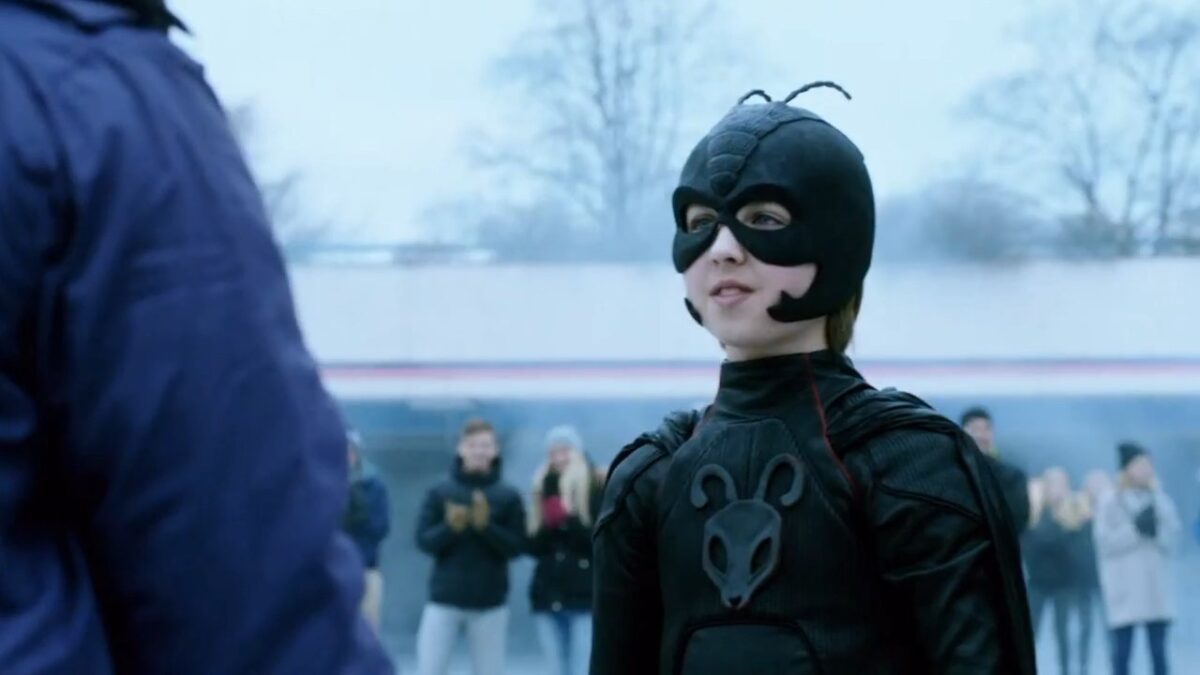 Oscar Dietz caracterizado como Pelle Nohrmann usando uniforme preto de super-herói em cena do filme Garoto Formiga: A Vingança da Fúria Vermelha