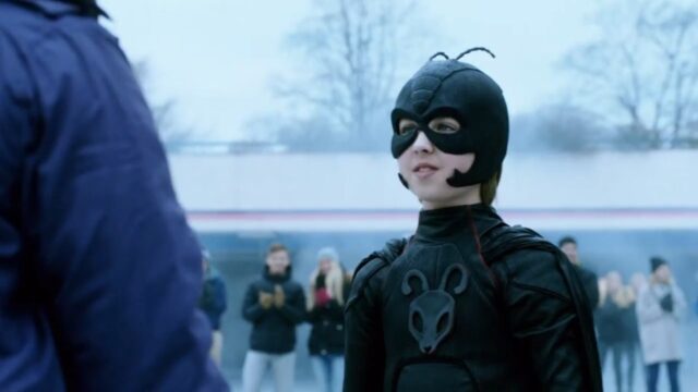 Oscar Dietz caracterizado como Pelle Nohrmann usando uniforme preto de super-herói em cena do filme Garoto Formiga: A Vingança da Fúria Vermelha