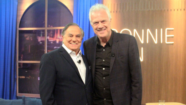 Ronnie Von e Pedro Bial sorrindo lado a lado no estúdio do programa Companhia Certa com letreiro iluminado ao fundo
