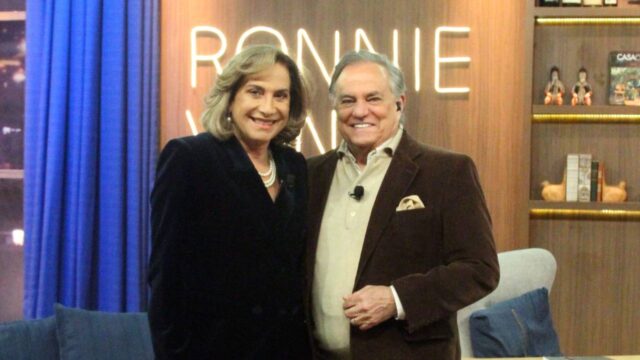 A atriz Totia Meirelles sorrindo ao lado do apresentador Ronnie Von no cenário do programa Companhia Certa