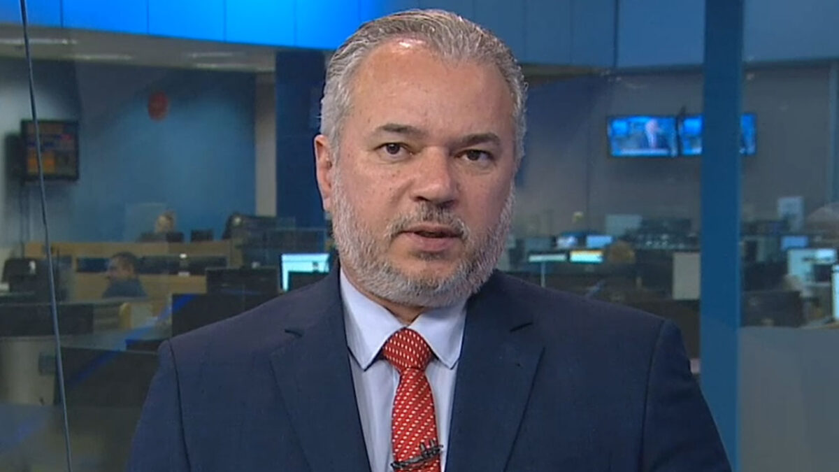 Wilson Soler de terno azul e gravata vermelha apresenta o Boa Noite Paraná da RPC em estúdio de jornalismo