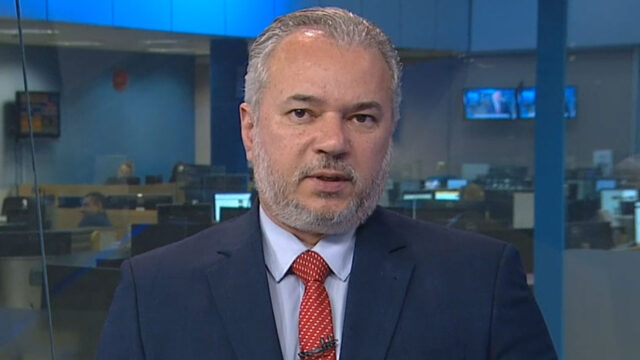 Wilson Soler de terno azul e gravata vermelha apresenta o Boa Noite Paraná da RPC em estúdio de jornalismo