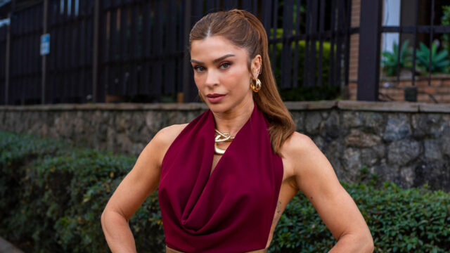 Grazi Massafera caracterizada como Arminda com blusa vinho e cabelo preso em cena da novela Três Graças