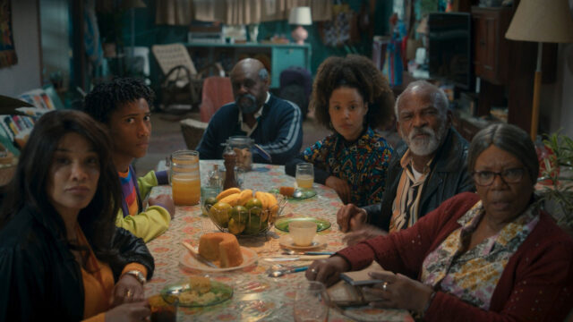 Elenco de Clube Spelunca sentado à mesa com comida e bebidas em cena da série da HBO Max