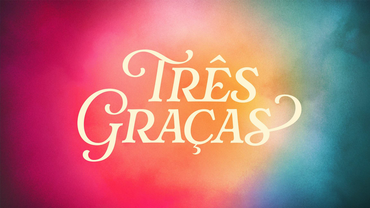 Logotipo da novela Três Graças com letras brancas sobre fundo colorido em tons de rosa, laranja e azul