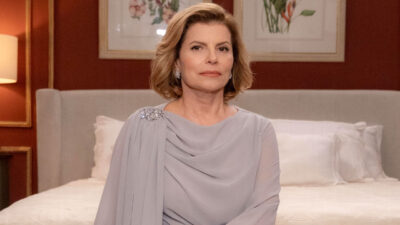 Débora Bloch como Odete Roitman com vestido elegante e expressão séria no quarto luxuoso do set de Vale Tudo