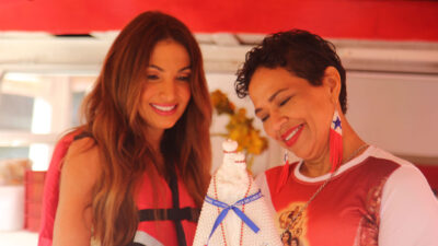 Patrícia Poeta e a empresária Joana Vieira observam imagem de Nossa Senhora de Nazaré decorada com fitas durante cobertura do Círio de Nazaré em Belém