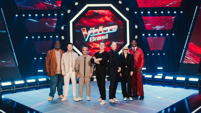 Péricles, Matheus & Kauan, Boninho, Tiago Leifert, Duda Beat e Mumuzinho posam juntos no palco iluminado do The Voice Brasil