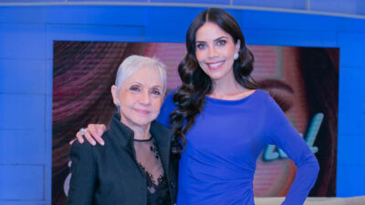 Cininha de Paula com cabelos brancos e Daniela Albuquerque de vestido azul, abraçadas no palco do programa Sensacional