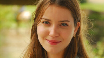 Nathalia Dill como Maria Rita, a Santinha, sorrindo e olhando para a câmera em cena da novela Paraíso