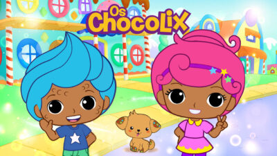 Desenho animado Os Chocolix com os personagens Chocomark de cabelo azul e Chocolyne de cabelo rosa em frente a casas de doces