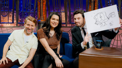 Tadeu Mello, Ale McHaddo e Danilo Gentili no sofá do The Noite, com Gentili segurando uma lousa branca com desenho de Osmar
