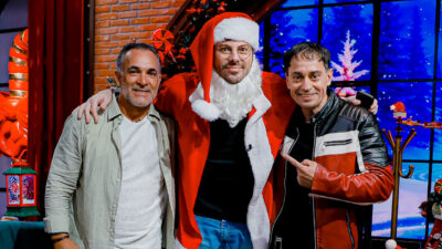 Dino dos Santos e Gutemberg Lins posam com Danilo Gentili vestido de Papai Noel no cenário temático de Natal do programa The Noite