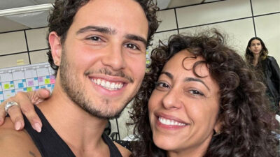 Igor Jansen, ator com cavanhaque, e Samantha Schmütz, atriz com cabelo cacheado, sorriem em selfie nos bastidores de produção