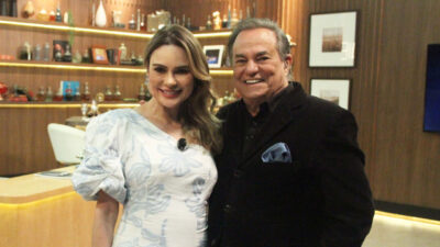 A jornalista Rachel Sheherazade e o apresentador Ronnie Von posam sorrindo juntos no cenário do programa Companhia Certa