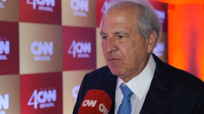 Rubens Menin de terno e gravata azul concede entrevista ao microfone da CNN Brasil em evento de aniversário de 4 anos da emissora