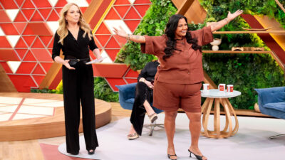 Christina Rocha apresenta o Casos de Família enquanto Gilzona abre os braços sorrindo no palco do programa com cenário colorido ao fundo