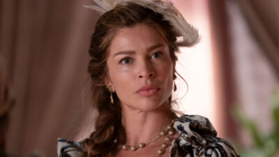 Grazi Massafera como Dona Beja com adorno de penas na cabeça e colar de pérolas em cena da novela original produzida para a HBO Max