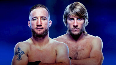 Justin Gaethje com tatuagem no braço e Paddy Pimblett de cabelo loiro tigela posam sem camisa com braços cruzados e fundo azul