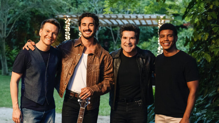 Michel Teló, João Raul interpretado por Filipe Bragança, Daniel e Luan vivido por Lucas Wickhaus sorrindo juntos nos bastidores de gravação de Coração Acelerado em sítio
