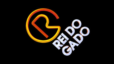 Logotipo da novela O Rei do Gado com a letra R estilizada em degradê laranja dentro de um círculo incompleto e o título escrito em branco inclinado