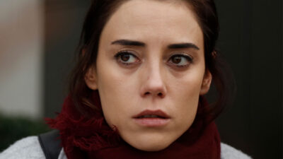 Cansu Dere como Zeynep Gunes encara o horizonte com olhar de preocupação e olhos marejados em cena dramática da novela turca Mãe