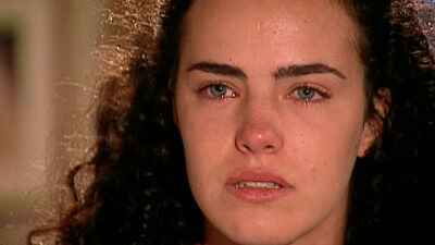 Ana Paula Arósio interpreta Giuliana na novela Terra Nostra, aparece em close com olhos marejados e expressão de sofrimento, cabelos escuros e presos