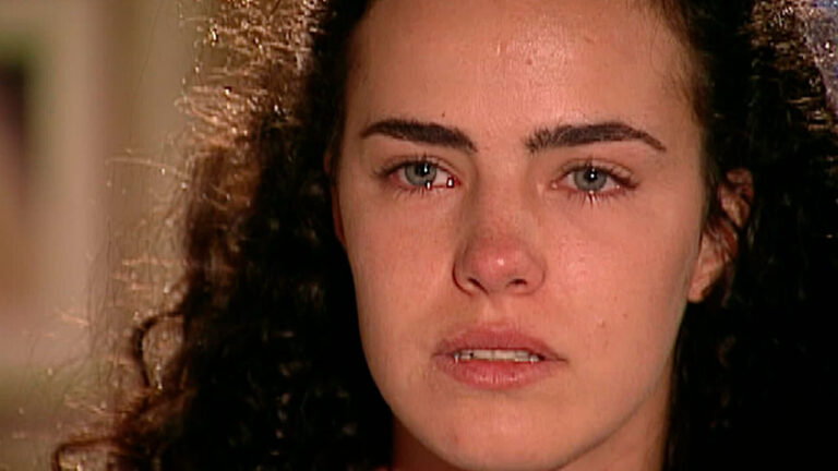 Ana Paula Arósio interpreta Giuliana na novela Terra Nostra, aparece em close com olhos marejados e expressão de sofrimento, cabelos escuros e presos