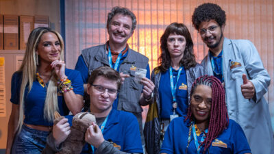 Luisa Perisse, Leandro Ramos, Rafael Saraiva, Renata Gaspar, Vilma Melo e João Pimenta posam como o elenco de Bolão da Firma em um cenário de escritório