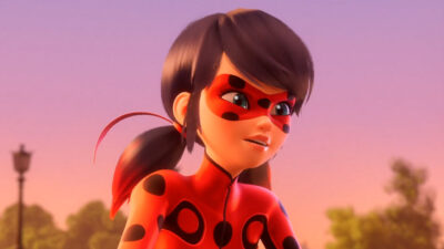Personagem Ladybug da animação Miraculous com máscara e uniforme vermelho de bolinhas pretas, cabelos azuis presos em maria-chiquinha e fundo de pôr do sol