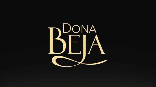 Logotipo da novela Dona Beja escrito em letras douradas e elegantes, com destaque para a letra B alongada, centralizado sobre um fundo preto fosco