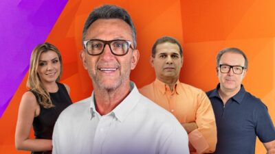 Marília Ruiz, Craque Neto, Oscar Roberto Godói e Leandro Quesada sorriem em estúdio com fundo laranja e roxo, tendo uma bola de futebol em destaque