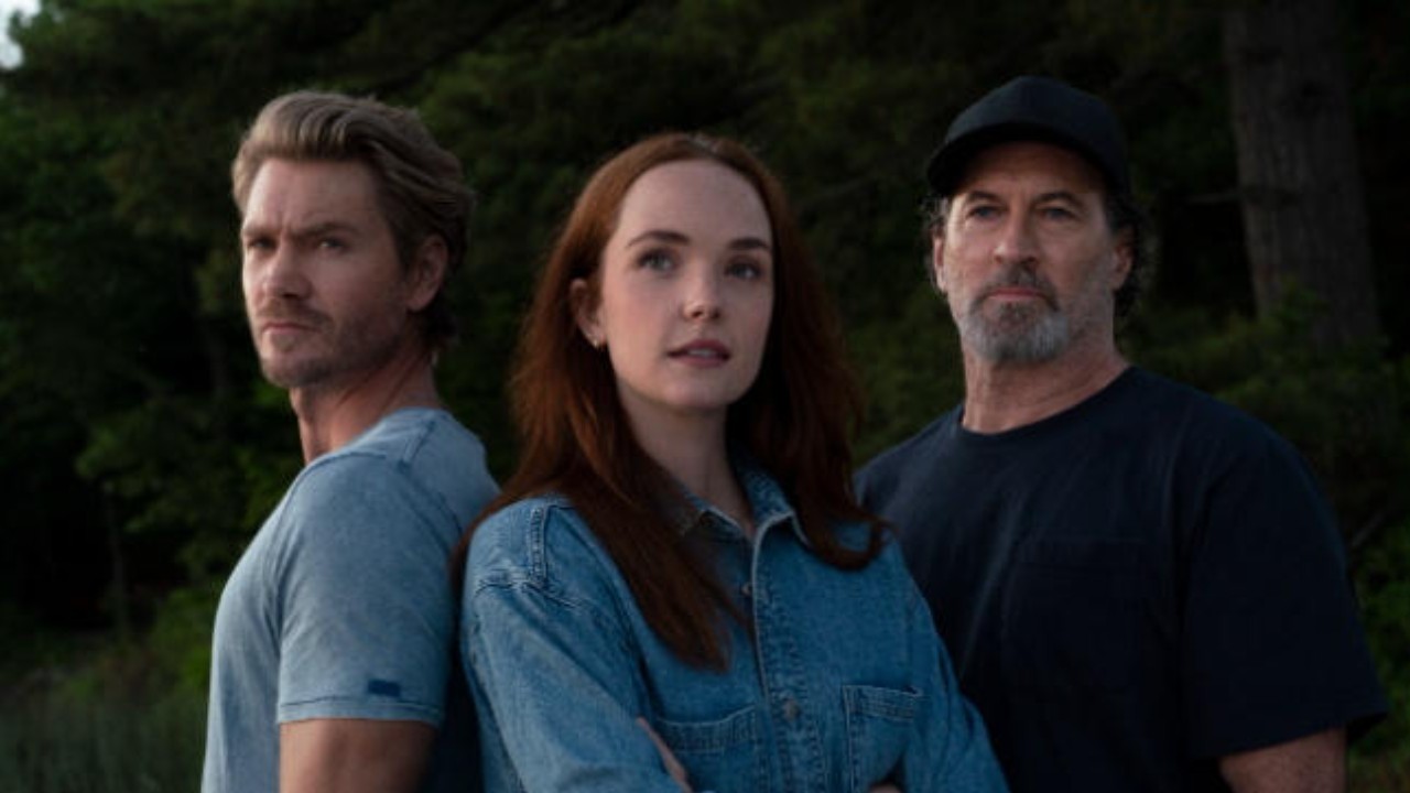 Chad Michael Murray como Cal, Morgan Kohan como Maggie e Scott Patterson como Harry posam sérios em cenário de floresta na série Sullivans Crossing