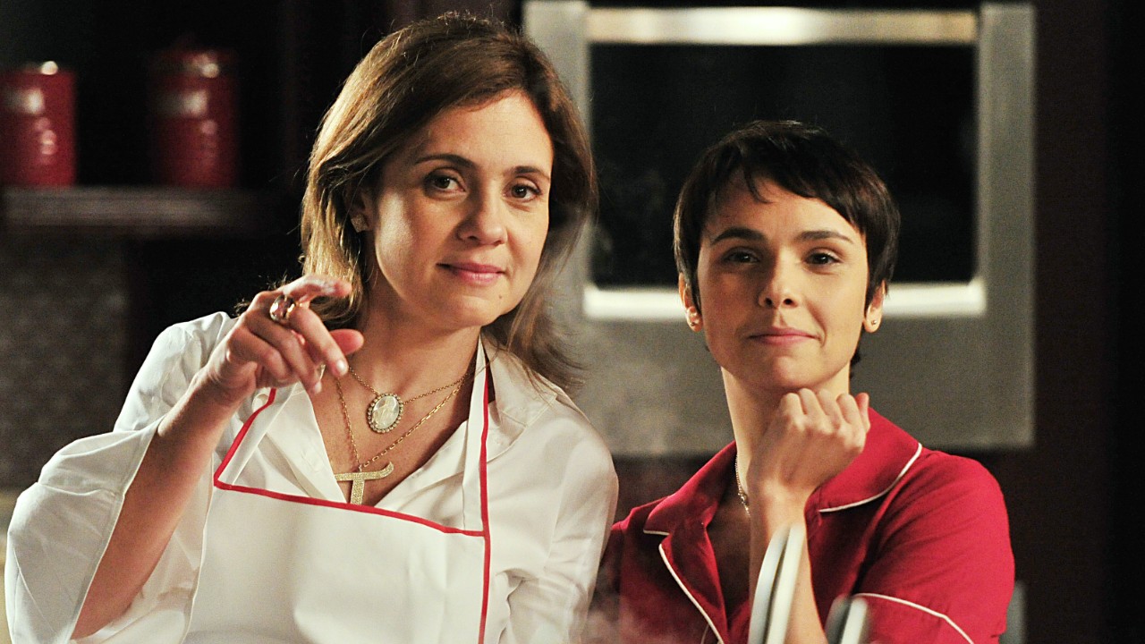 Carminha (Adriana Esteves) e Nina (Débora Falabella) observam algo na cozinha em cena da novela Avenida Brasil