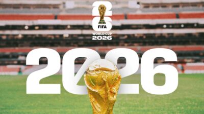 Troféu da Copa do Mundo centralizado com logotipo FIFA World Cup 2026 e número 2026 sobre estádio de futebol ao fundo