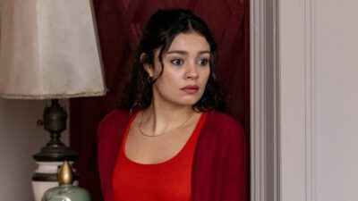 Atriz Sophie Charlotte como Gerluce na novela Três Graças, veste blusa e cardigã vermelhos, expressa preocupação e olha para o lado em cenário interno