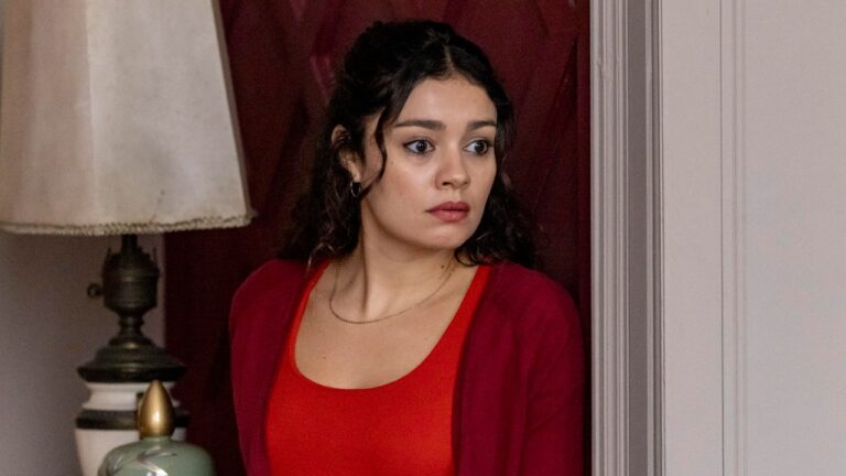 Atriz Sophie Charlotte como Gerluce na novela Três Graças, veste blusa e cardigã vermelhos, expressa preocupação e olha para o lado em cenário interno