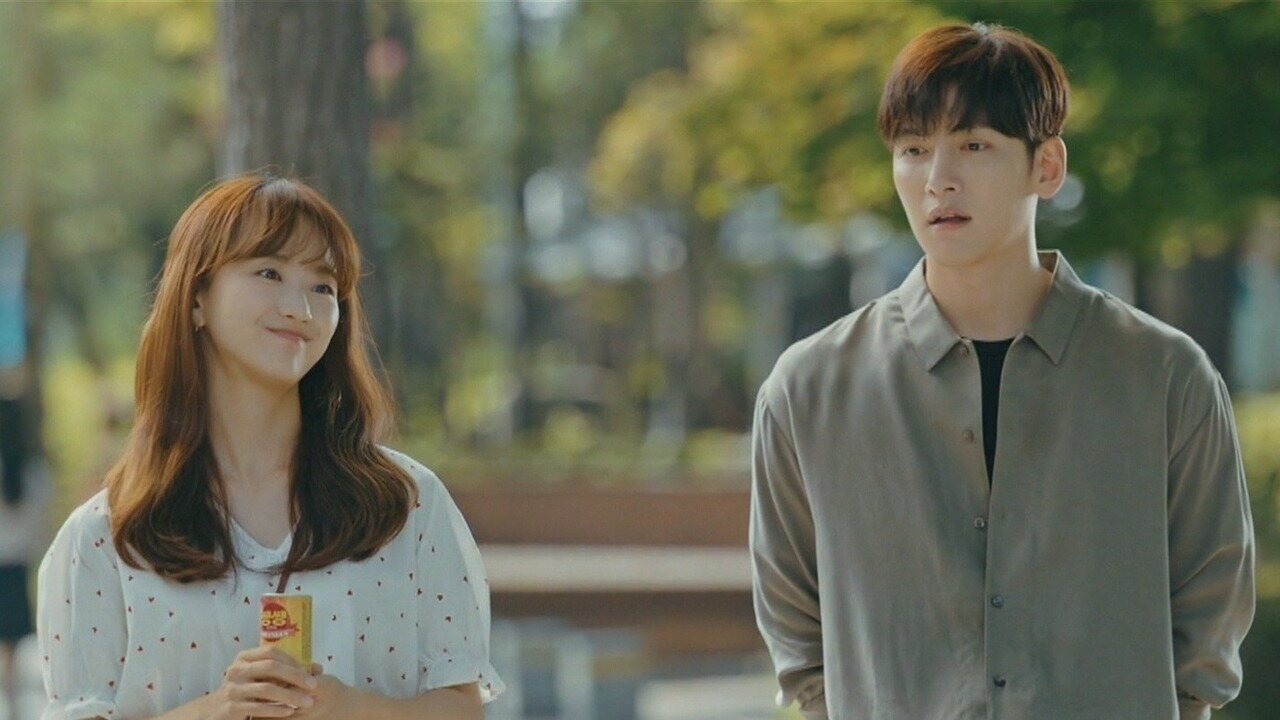 Won Jin Ah como Ko Mi Ran e Ji Chang Wook como Ma Dong Chan sorriem alegremente enquanto caminham juntos em rua arborizada no dorama Derretendo Pouco a Pouco
