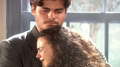 Thiago Lacerda como Matteo e Ana Paula Arósio como Giuliana se abraçam chorando em cena da novela Terra Nostra, ele veste terno e ela tem cabelos ondulados