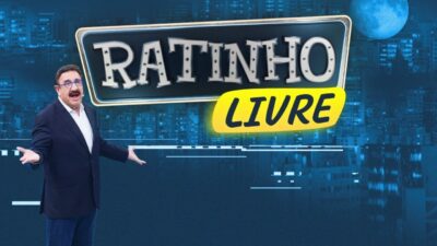 Apresentador Ratinho ao lado do logo Ratinho Livre em cenário noturno com cidade ao fundo
