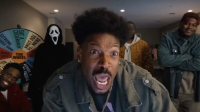 Marlon Wayans expressa pânico em primeiro plano, cercado por amigos e o vilão Ghostface de Pânico, ao lado de uma roleta colorida de desafios bizarros